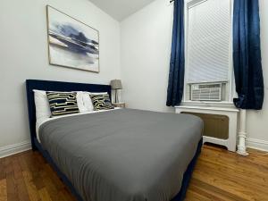 a bedroom with a bed and a window with blue curtains at Lincoln Center New York in New York