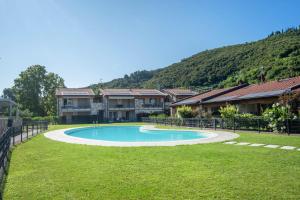 a swimming pool in the middle of a yard with houses at ApartmentsGarda - Garda31 Residence in Garda