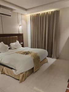 a bedroom with a large bed and a window at نيلوفر فور محايل عسير in Muhayil