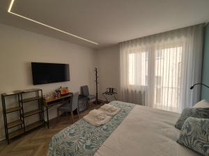 a bedroom with a bed and a desk and a television at 3 Amici all'Arena in Verona