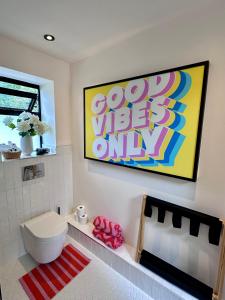 a bathroom with a toilet and a painting on the wall at Private room with ensuite and small double bed in Hackington +4 photos