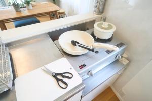 a kitchen counter with a sink and a pair of scissors at Koeda House in Tokyo