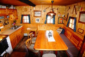 a kitchen with a wooden table in a cabin at Bergheim Schmidt Ski-In Ski-Out Appartements Almhütten im Wald in Turracher Hohe