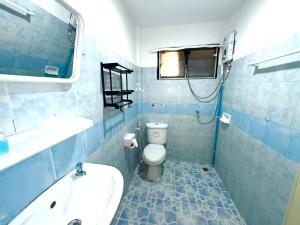 een blauw betegelde badkamer met een toilet en een wastafel bij Patong Canal Villa 305 in Patong Beach
