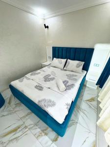 een bed met een blauw hoofdeinde in een kamer bij home hotel registan in Samarkand +12 foto's