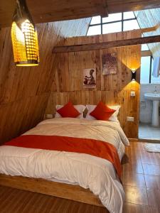 a bedroom with a large bed with red pillows at Kaasham Cabins Olpejeta in Nanyuki