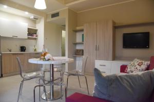 a living room with a table and chairs and a kitchen at Costa Verde Natura in Clusane sul Lago