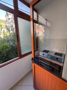 a kitchen with an open door with a stove at Apartament Eljo in Çorovodë +1 photo