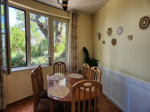 a dining room with a table and chairs and windows at Villa Sunrise in Draç