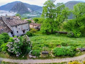 an old house in a garden with mountains in the background at Chambres d'Hotes - Queen bed, Gorges du Verdon in Castellane