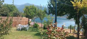 a garden with a table and chairs and a view of the water at Lake of Diber in Debar