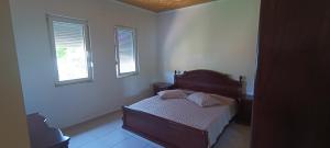 a small bedroom with a bed and two windows at Lake of Diber in Debar