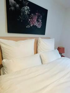 a bed with white pillows and a painting on the wall at Naturerlebnis direkt am Traumpfad in Andernach