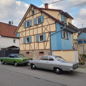 two old cars parked in front of a house at Ferienwohnung Alte Schmiede in Herbolzheim