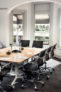 una sala de conferencias con una gran mesa de madera y sillas en Holiday Inn West Perth, an IHG Hotel, en Perth