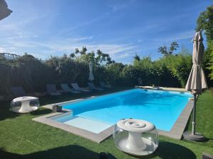 a swimming pool with two chairs and an umbrella at ZenVerand in Saint-Vérand