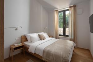 ロヴィニにあるCasa Mariaのベッドと窓のある白い寝室