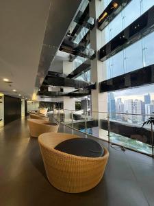 a lobby with chairs and tables and a large window at Gramercy Makati Condotel in Manila