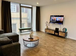 ein Wohnzimmer mit Couch und Flachbildfernseher in der Unterkunft ROSIS HOME Geräumige Citywohnung im Herzen Schorndorfs - Ideal für Gruppen und Familen in Schorndorf