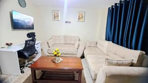 a living room with a white couch and a table at ElleHomesKe-Imani 2, Ruiru-Kamakis in Ruiru +1 photo