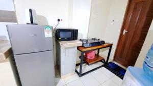a kitchen with a refrigerator and a table with a microwave at ElleHomesKe-Imani 2, Ruiru-Kamakis in Ruiru