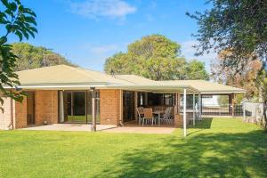 a brick house with a roof and a patio at Duke Street Hideaway in Busselton