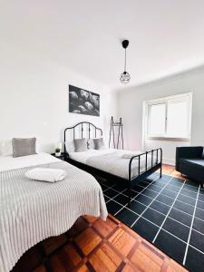 a bedroom with two beds and a couch at Luxury rooms next attractions and station in Lisbon