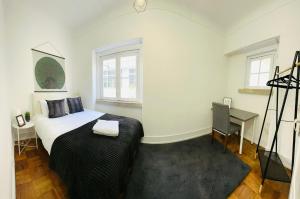 a bedroom with a bed and a desk in it at Luxury rooms next attractions and station in Lisbon