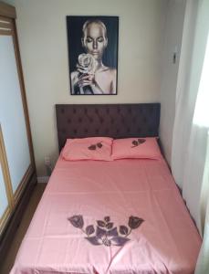 a bed with pink sheets and a black and white picture at Belém Cop 30 in Belém +4 photos