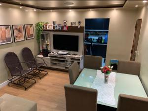 a living room with a table and chairs and a television at Belém Cop 30 in Belém