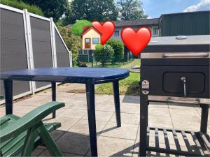 a blue table with two hearts next to a grill at Romantisches ganzes Apartment Parkplatz Waschmaschine Kamin Terrasse Garten, Grill und Küche in Duisburg