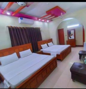 a room with two beds in a room with at Royal Residency Guest House Karachi in Karachi