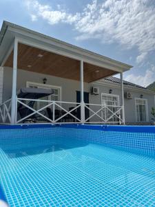 a house with a swimming pool in front of a house at Qafqaz Hills Villa in Gabala