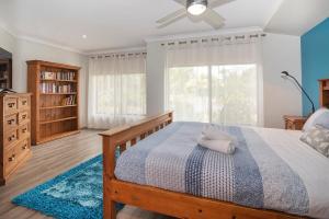 a bedroom with a bed and a large window at Just Chillin- Pool, 2km to beach in Broadwater