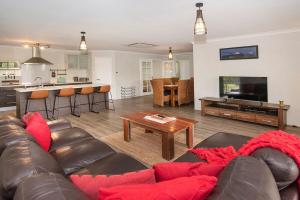 a living room with a couch and a table at Just Chillin- Pool, 2km to beach in Broadwater