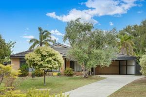 a house with a driveway and trees in front of it at Just Chillin- Pool, 2km to beach in Broadwater