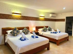 a room with two beds with hats on them at Alona Garden Suites in Panglao Island