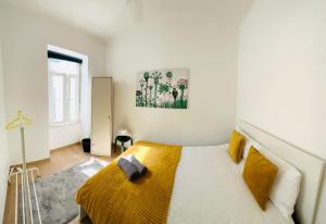 a bedroom with a bed with a yellow blanket at Luxury house next attractions with free parking in Lisbon +22 photos