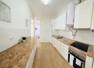 a kitchen with white cabinets and a wooden floor at Luxury house next attractions with free parking in Lisbon