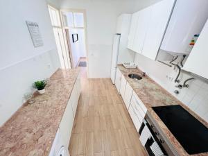 a kitchen with white cabinets and a wooden floor at Luxury house next attractions with free parking in Lisbon