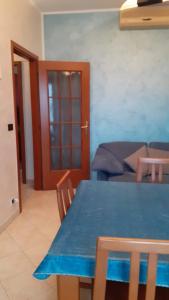 a dining room with a blue table and a couch at B&B Apartment in Settimo Torinese