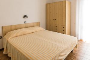 a bedroom with a bed and a wooden cabinet at Hotel Sabrina in Sottomarina