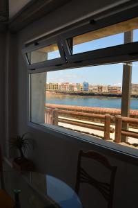 Una ventana con una mesa y vista al agua. en Ian's House, en La Garita