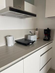 a kitchen with white cabinets and a counter top at Ian's House in La Garita