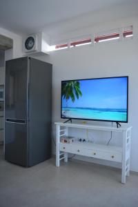 una sala de estar con TV de pantalla plana en un armario blanco en Ian's House, en La Garita