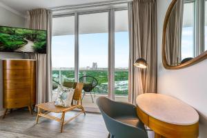 a living room with a table and chairs and a large window at Elegant 2BR Condo at Hotel Arya Full Kitchen Wraparound Views 2 Parking Spots in Miami