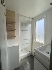 a bathroom with a white refrigerator and a sink at Maria Meco in Sesimbra