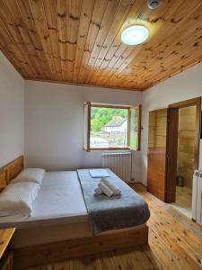 a bedroom with a bed with a wooden ceiling at Mik Hotel Vermoshi in Vermosh