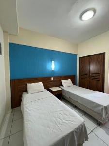 a room with two beds and a blue wall at Joalpa Hotel in Juiz de Fora +35 photos