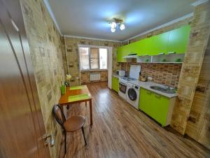 a kitchen with green cabinets and a table and a sink at Cozy flat apartment in Chişinău